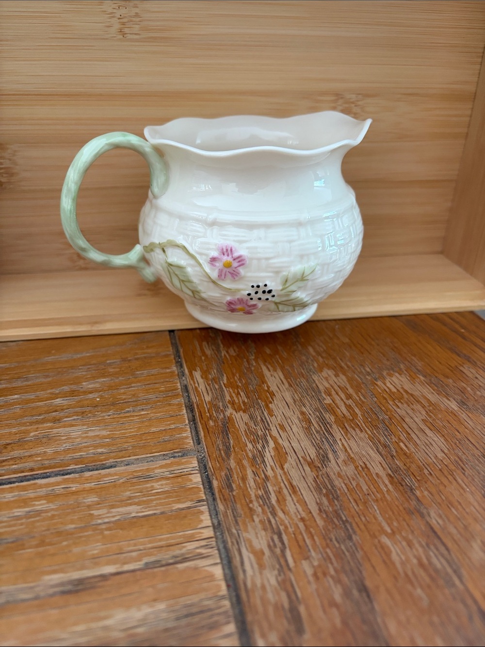 Belleek Cream Ceramic Pitcher with Pink Floral Motif and Green Handle
